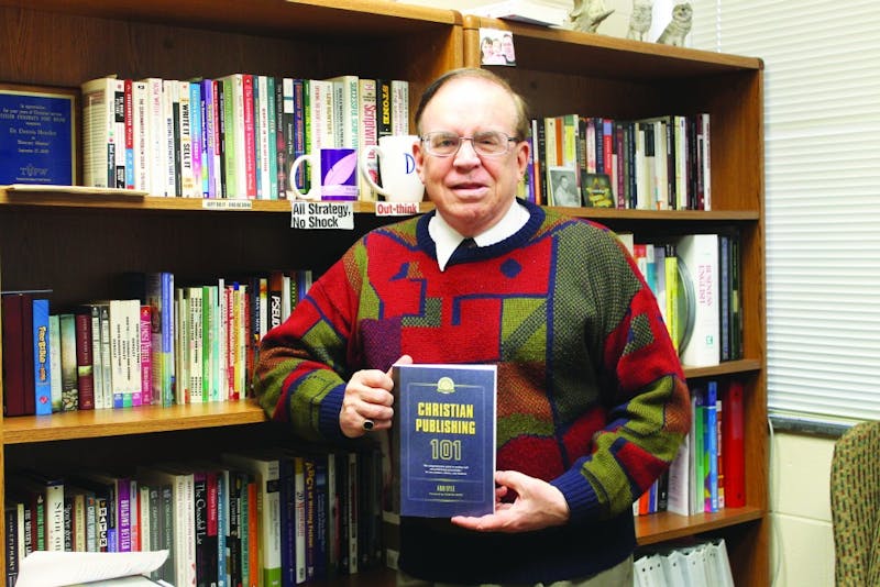 Professor Dennis Hensley proudly holds “Christian Publishing 101.” (Photograph by Ruth Flores-Orellana)