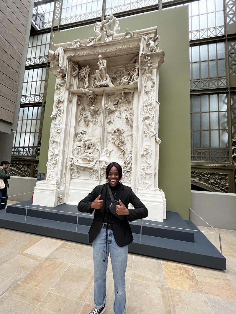 Patience Sakeuh stands in a Parisian art museum.