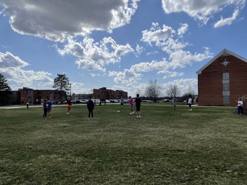 Students play soccer outside on the lawn.