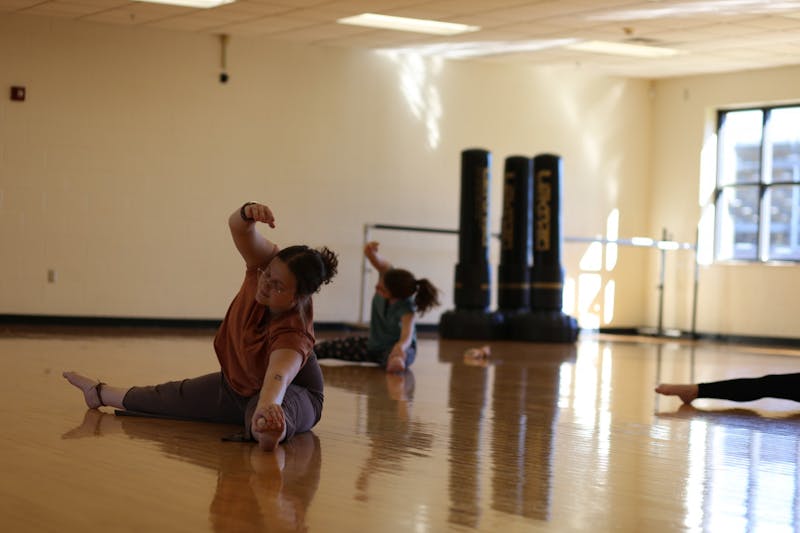 Junior Emily Mitchell, the founder of Unity Dance Alliance, leads fellow dancers in stretches.