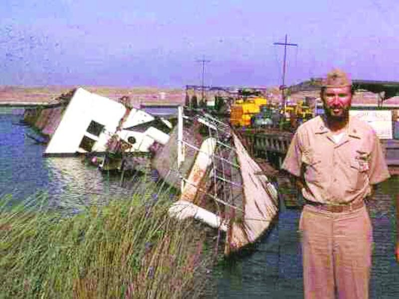 Pictured in his uniform, Harbin stands along the Suez Canal in Egypt where he was a part of the mine-clearance operation after the 1973 “October War.” The ship in the background was scuttled by the Egyptians to block the canal during the war. (Photograph provided by Michael Harbin)