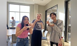 Zoey Newyof, Anna Priest and Kim Sungmin eating Korean snacks at an Korean club event
