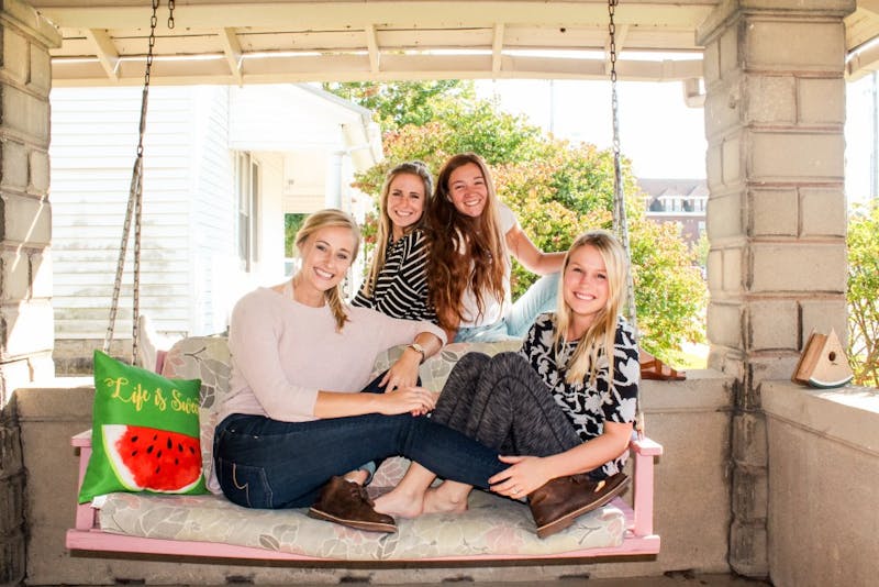 Seniors Natalie Rupp, Danielle Straits, Kylie McCloughan and Ally Helmkamp enjoy the large porch at the front of the “Watermelon House.”