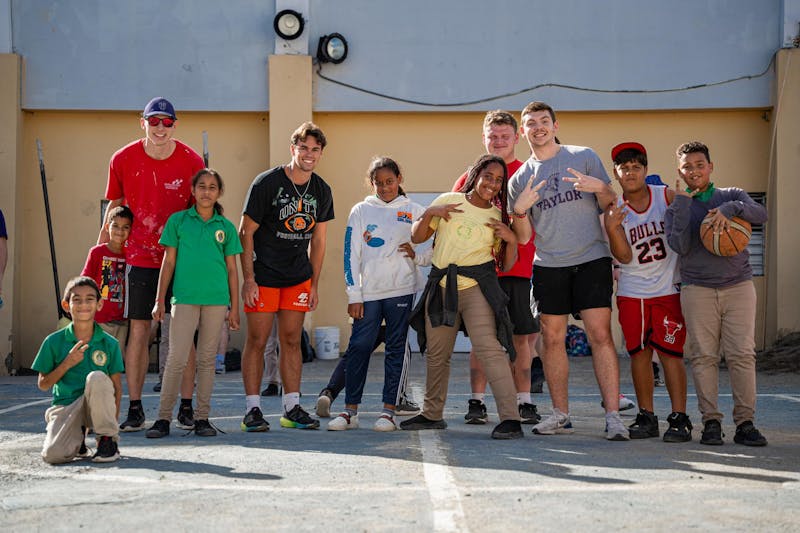 Members of Taylor’s football team pose with students in Jarabacoa.