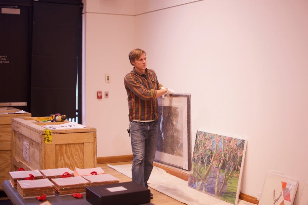 Gallery curator Jeremie Riggleman sets up the new exhibit.