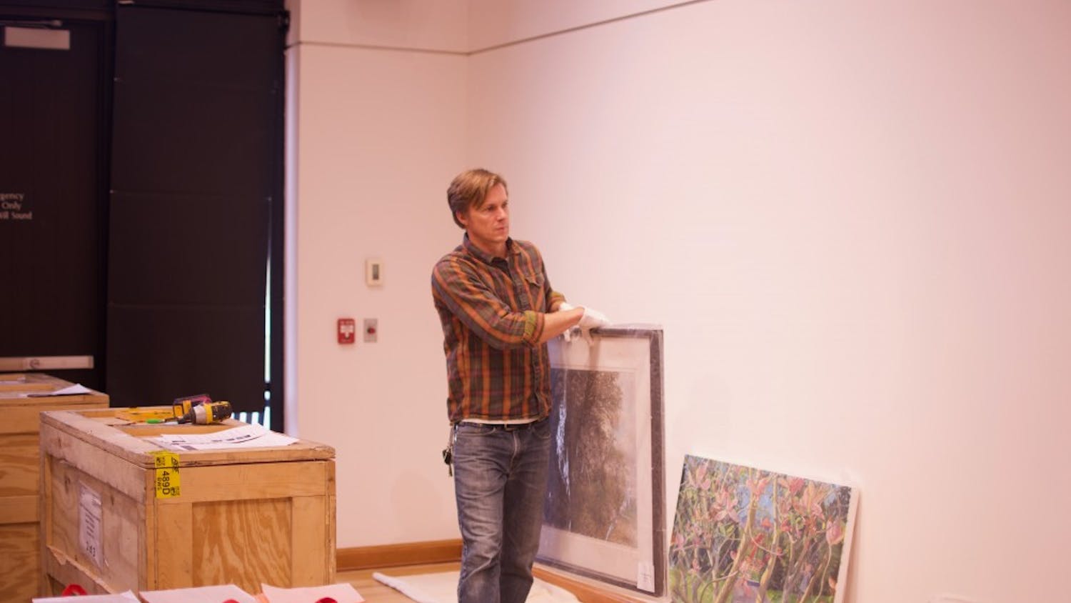 Gallery curator Jeremie Riggleman sets up the new exhibit.