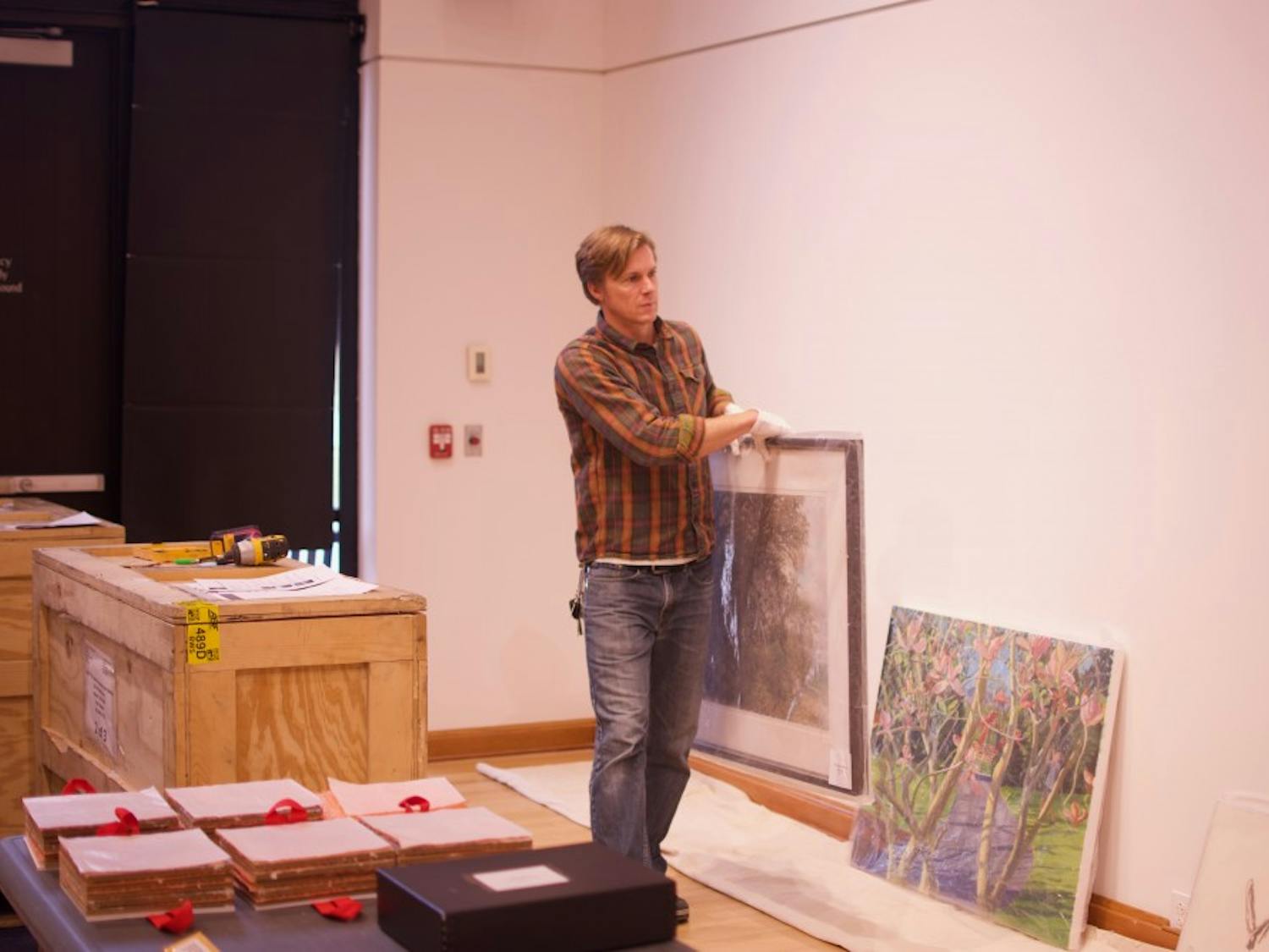 Gallery curator Jeremie Riggleman sets up the new exhibit.