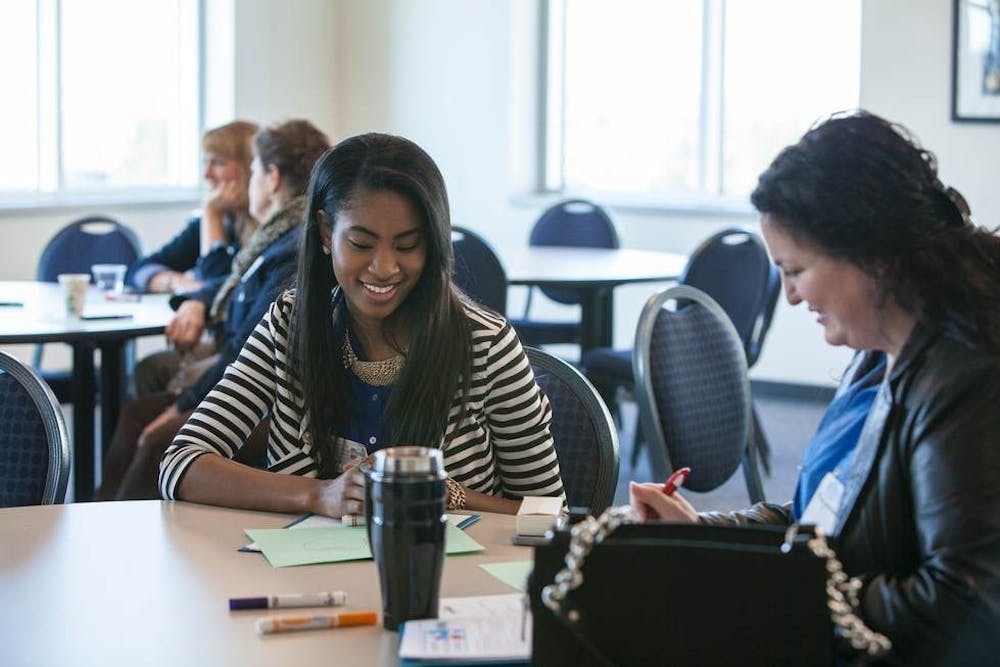 female-student-at-table-with-female-prof-talking-rgb