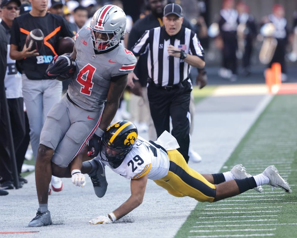 Buckeyes wide receiver Jeremiah Smith (4) is forced out of bounds by Hawkeyes defensive back Sebastian Castro (29) during second half action in the college football game between the Ohio State Buckeyes and Iowa Hawkeyes in Columbus on Saturday, October 5, 2024.  The Buckeyes won 35-7. (David Petkiewicz/Tribune Content Agency)