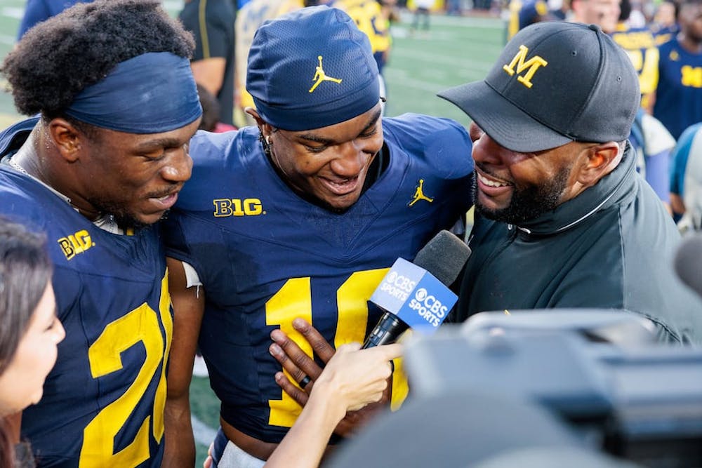 Michigan Wolverines head coach Sherrone Moore is interviewed with Michigan Wolverines quarterback Alex Orji (10) and Michigan Wolverines running back Kalel Mullings (20) after Michigan football defeated the University of Southern California at Michigan Stadium in Ann Arbor on Saturday, Sept. 21, 2024. (Jacob Hamilton/Tribune Content Agency)