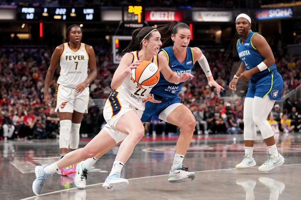 The Indiana Fever's Caitlin Clark (22) drives against the Minnesota Lynx' Bridget Carleton (6) during the second half at Gainbridge Fieldhouse on Friday, Sept. 6, 2024, in Indianapolis. (Emilee Chinn/Getty Images/TNS)