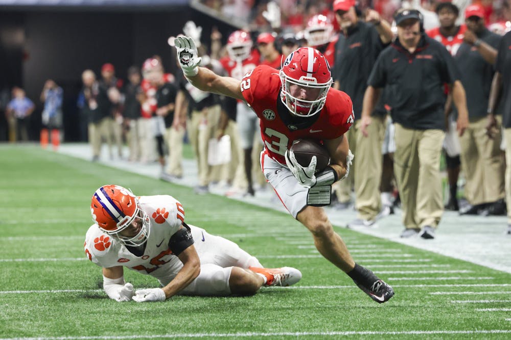 Georgia running back Cash Jones (32) runs against Clemson cornerback Jeadyn Lukus (10) as he scores a 15-yard touchdown during the second half at Mercedes-Benz Stadium, on Saturday, Aug. 31, 2024, in Atlanta. Georgia won 34-3. (Jason Getz / AJC)