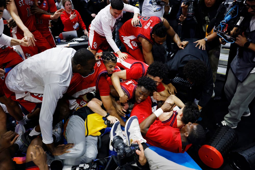 Dylan Darling (0), bottom right, of the St. John's Red Storm is mobbed by teammates after making the game-winning shot against Kansas during the second round of the NCAA Men's Basketball Tournament at Viejas Arena on Sunday, March 22, 2026, in San Diego. (K.C. Alfred/The San Diego Union-Tribune/TNS)