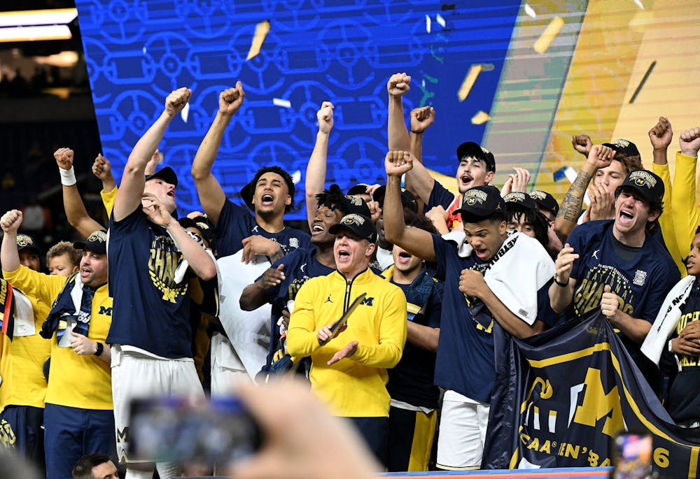 The Michigan players and coaches sing the Michigan fight song on the stage during the post game celebration. Michigan wins 69-63 over UConn at the NCAA men's basketball championship at Lucas Oil Stadium on April 6, 2026 in Indianapolis. Michigan wins, 69-63. (Robin Buckson, The Detroit News, Tribune Content Agency)