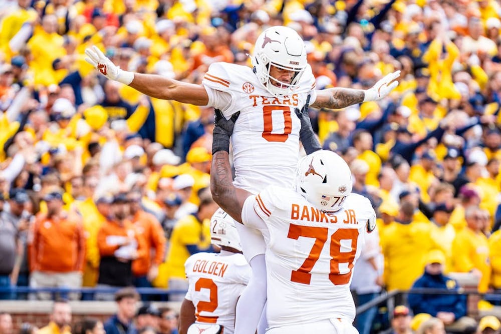 Texas Longhorns offensive lineman Kelvin Banks Jr. (78) holds up Texas Longhorns wide receiver DeAndre Moore Jr. (0) during Michigan vs Texas at Michigan Stadium in Ann Arbor on Saturday, Sept. 7, 2024. (Josh Boland/Tribune Content Agency)