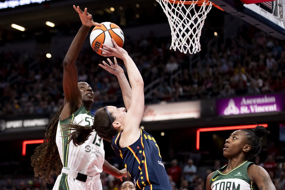 Caitlin Clark (22) of the Indiana Fever scores on a move to the basket while being defended by Ezi Magbegor (13) of the Seattle Storm during the first half at Gainbridge Fieldhouse on Sunday, Aug. 18, 2024, in Indianapolis. (Chet White/Getty Images/TNS)