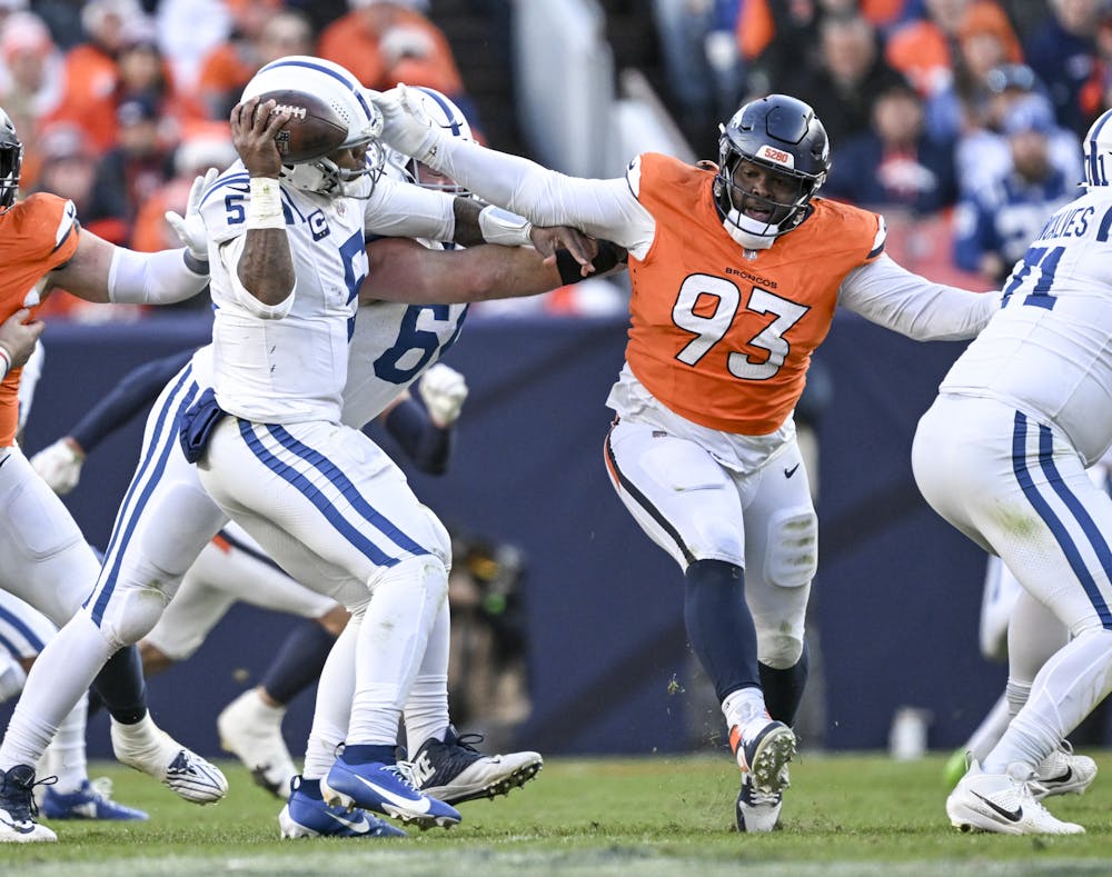 Anthony Richardson (5) of the Indianapolis Colts avoids a sack attempt by D.J. Jones (93) of the Denver Broncos during the second quarter at Empower Field at Mile High in Denver on Sunday, Dec. 15, 2024. (Photo by AAron Ontiveroz/The Denver Post/Tribune Content Agency)