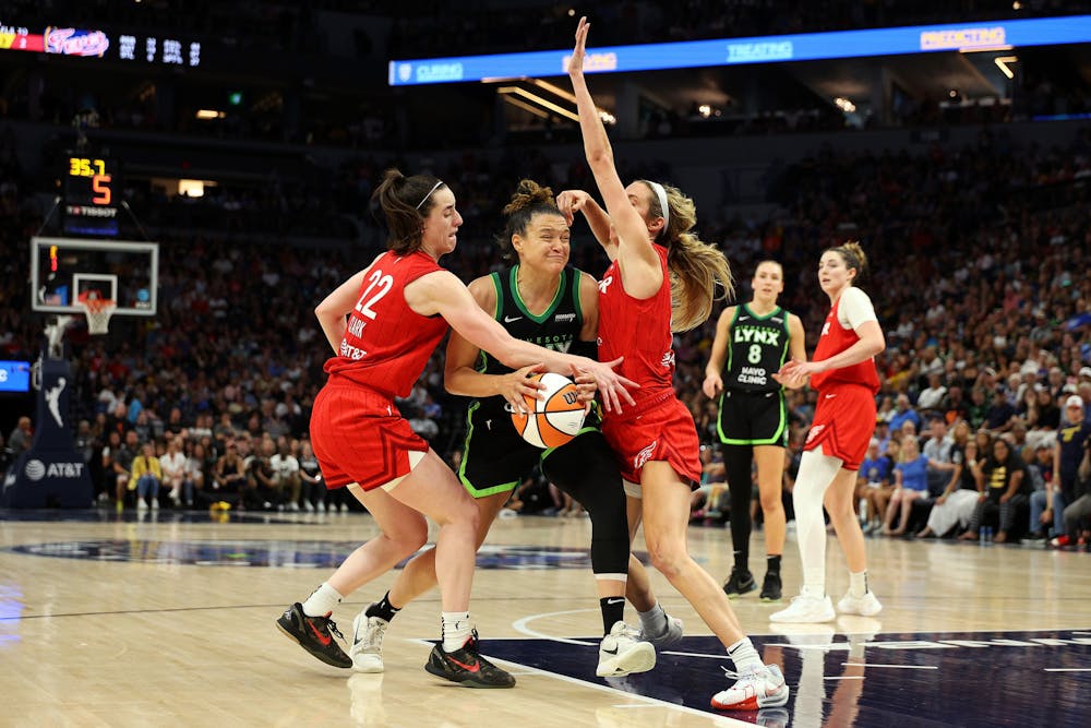 Kayla McBride (21) of the Minnesota Lynx drives to the basket against Caitlin Clark (22) and Lexie Hull (10) of the Indiana Fever in the fourth quarter at Target Center on Sunday, July 14, 2024, in Minneapolis. The Fever defeated the Lynx 81-74. (David Berding/Getty Images/TNS)