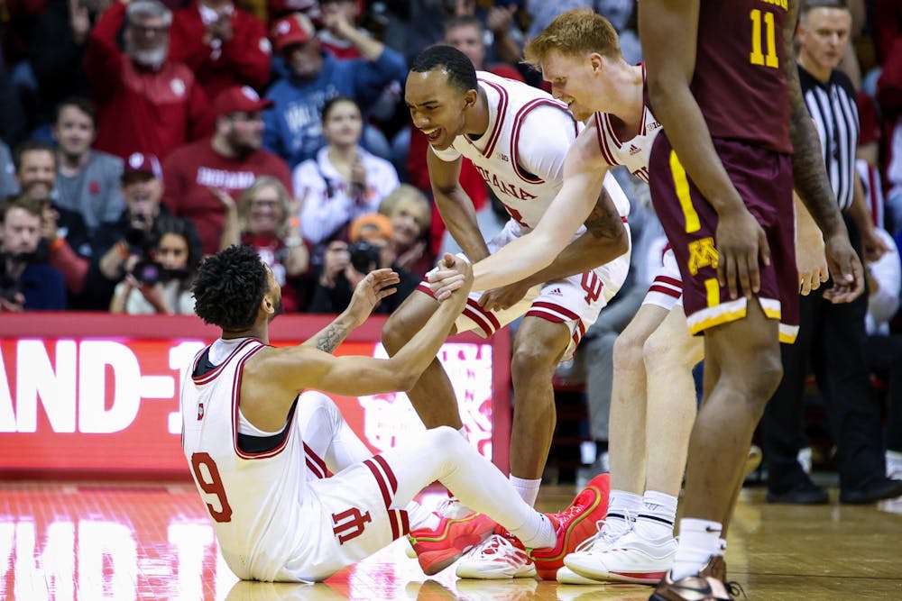 Bryson Tucker (center) and Luke Goode pick up teammate Kanaan Carlyle (9) during Indiana's win over Minnesota on Dec. 9, 2024. (HN photo/Jaren Himelick)