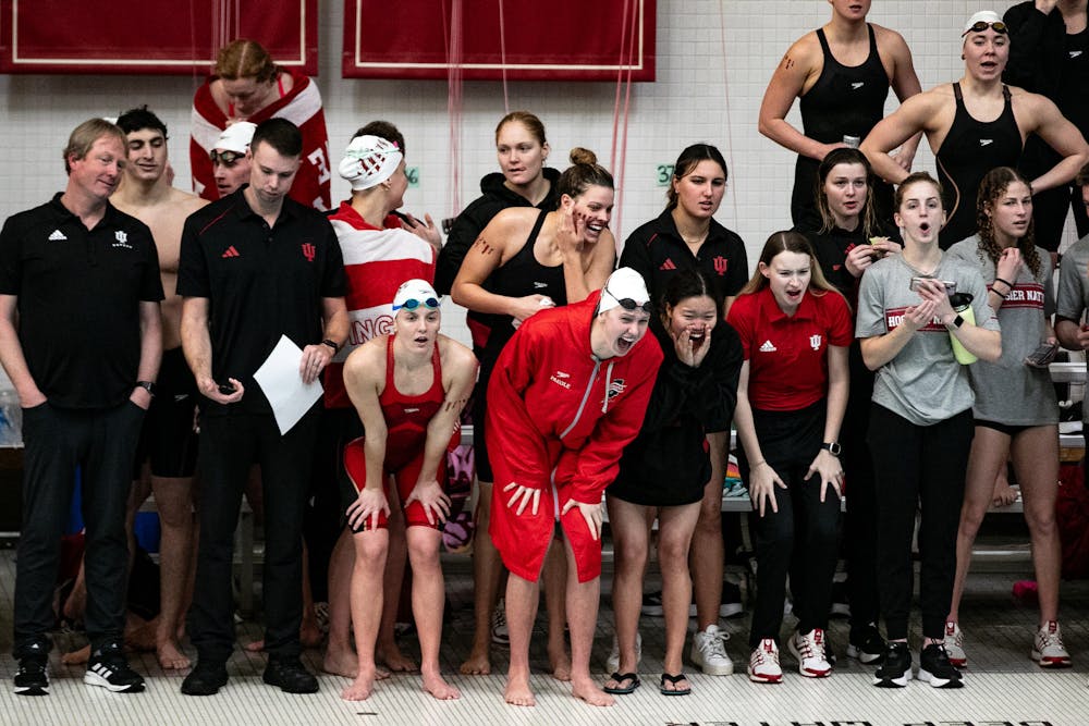 Indiana head coach Ray Looze (far left) and swimmers cheer on a relay team during Indiana's tri-meet victories against Wisconsin and Louisville on Feb. 2, 2024. (HN photo/Giselle Marsteller)
