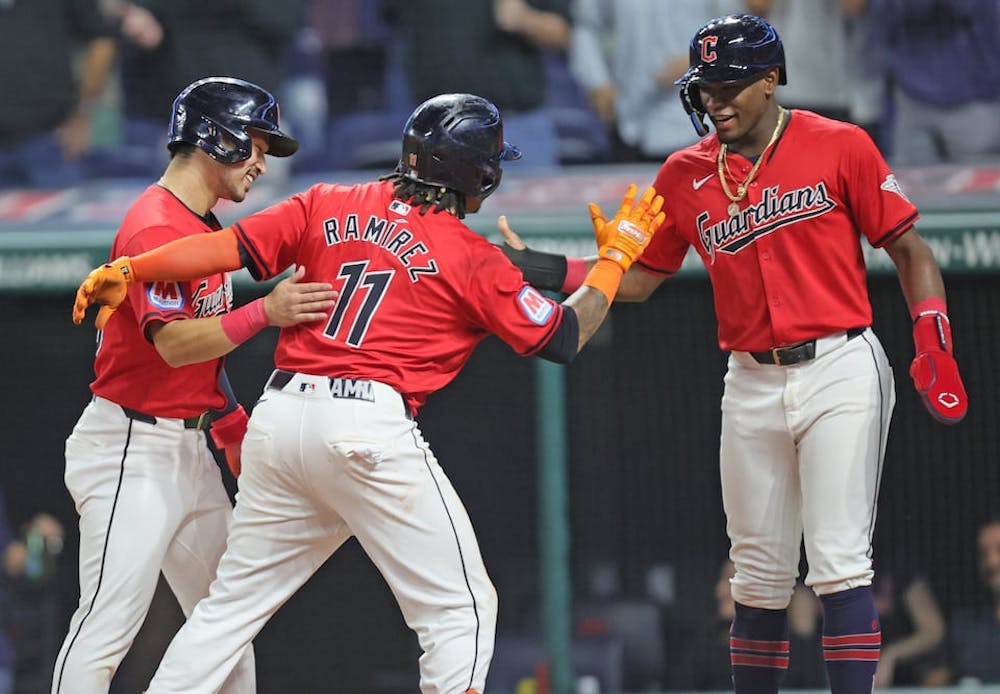 Cleveland Guardians Jose Ramirez (11) is congratulated by Steven Kwan (L) and Angel Martinez at home plate after Ramirez hit a three-run homer in the eighth inning at Progressive Field. (John Kuntz/Tribune News Service)