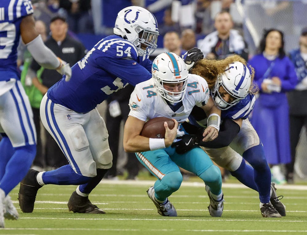 Miami Dolphins quarterback Tim Boyle (14) is taken down by Indianapolis Colts linebacker Grant Stuard (41) and defensive end Dayo Odeyingbo (54) late in the fourth quarter at Lucas Oil Stadium in Indianapolis on Sunday, Oct. 20, 2024. (Al Diaz/Miami Herald/TNS)