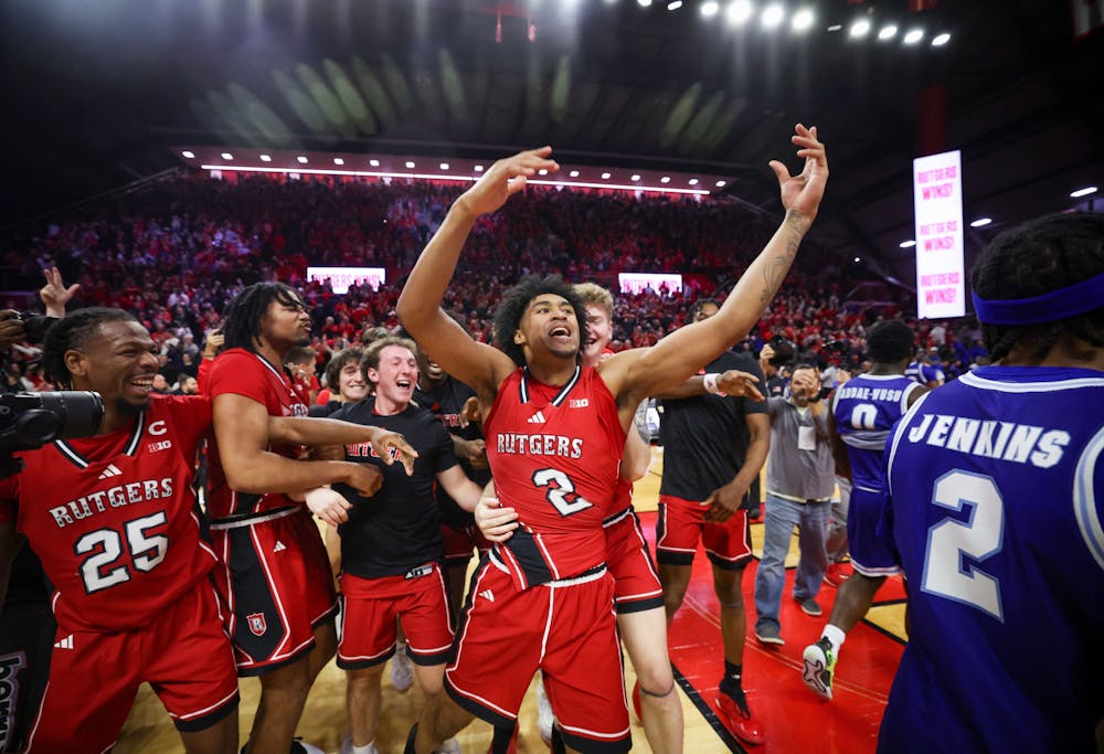 Rutgers players rush the floor to mob guard Dylan Harper (2) after he hit a three point basket at the buzzer to beat Seton Hall in the Garden State Hardwood Classic, Saturday, Dec. 14, 2024, in Piscataway, N.J.  The Scarlet Knights won, 66-63, thanks to Harper's heroics. (Andrew Mills/Tribune Content Agency)