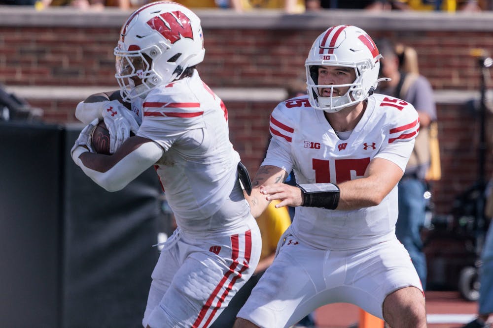 Wisconsin Badgers quarterback Hunter Simmons (15) hands off to Wisconsin Badgers running back Dilin Jones (7) as Michigan football hosts Wisconsin at Michigan Stadium in Ann Arbor on Saturday, Oct. 4 2025. (Jacob Hamilton/Tribune Content Agency)