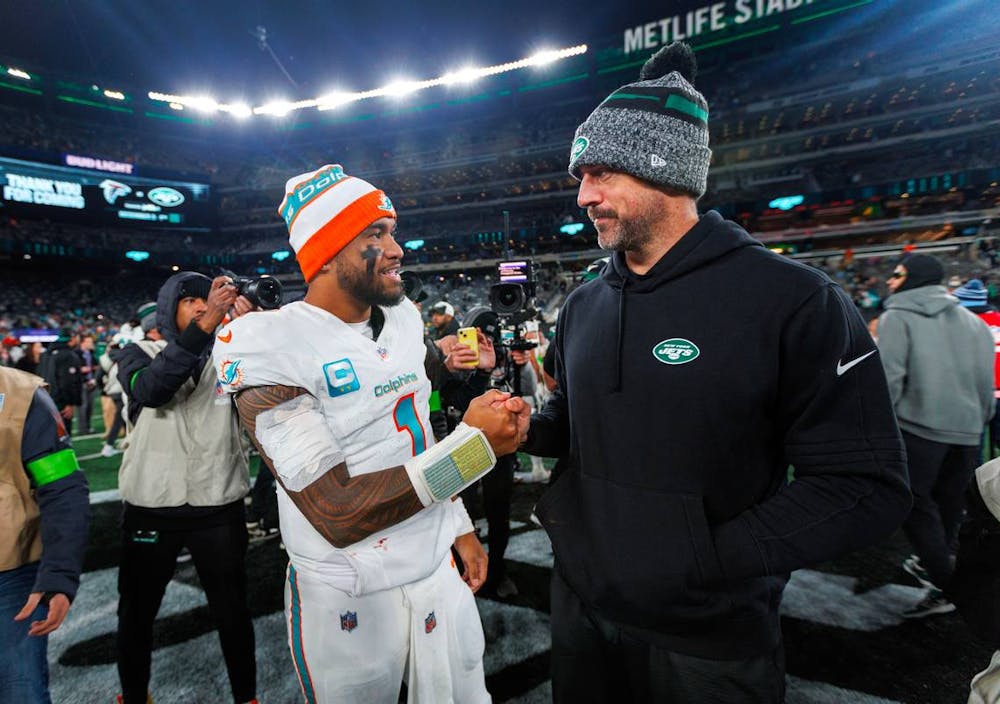 Miami Dolphins quarterback Tua Tagovailoa (1) interacts with New York Jets quarterback Aaron Rodgers (8) after the Dolphins 34-13 win over the Jets during an NFL football game at MetLife Stadium on Friday, Nov. 24, 2023 in East Rutherford, New Jersey. (Rodgers did not play because of an injury). (David Santiago/Tribune Content Agency)