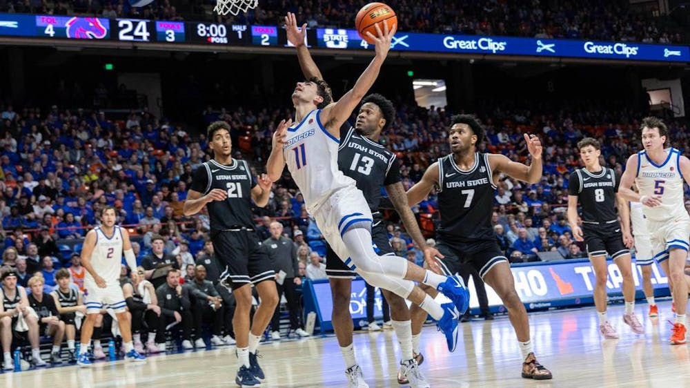 Boise State guard Alvaro Cardenas drives and draws a foul on Utah State guard Deyton Albury in the first half at ExtraMile Arena on Wednesday night. (Darin Oswald/Tribune Content Agency)