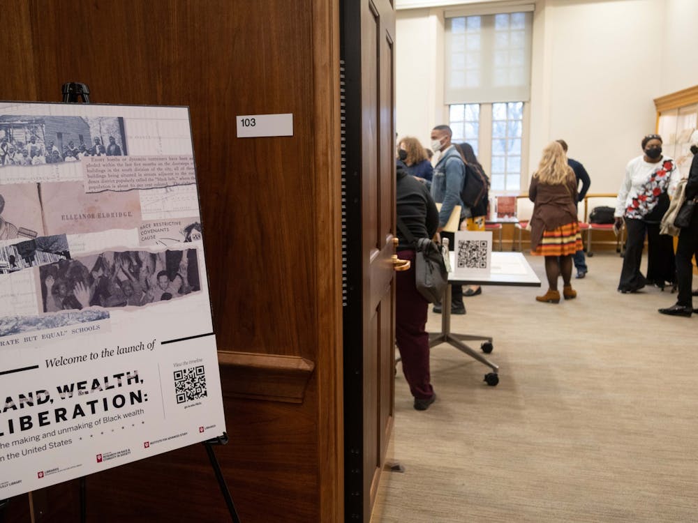 Patrons explore the pop-up exhibit of material from the Herman B Wells Library, Education Library and Lilly Library at the Land, Wealth, Liberation launch event. Librarians across the IU campus worked to compile a timeline called &quot;Land, Wealth, Liberation: The Making and Unmaking of Black Wealth in the United States,&quot; which includes sources and artifacts from 1820 to 2020.