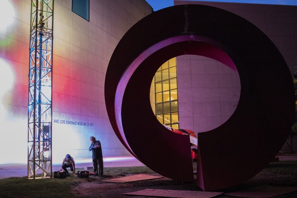 Giorgio Gikas and Terra Gillis prepare to buff the Indiana Arc sculpture July 13 in front of the Eskenazi Museum of Art.