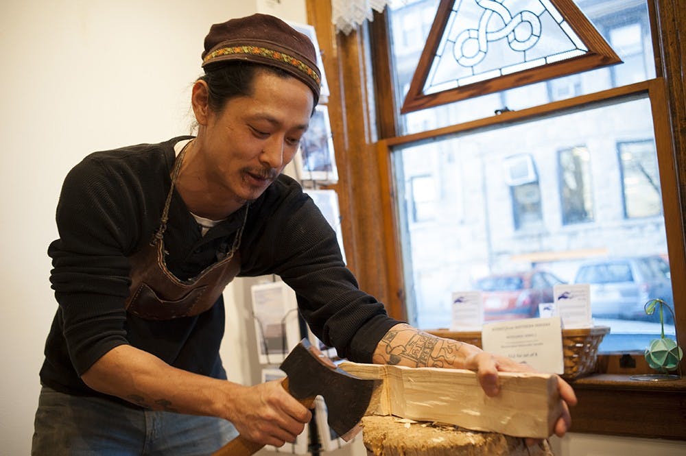 Kyle Pearson starts the spoon carving by making a frame of the spoon from a log with an axe. Pearson prefers using "green" or unseasoned timber as it is much softer and easier to shape with hand tools. 