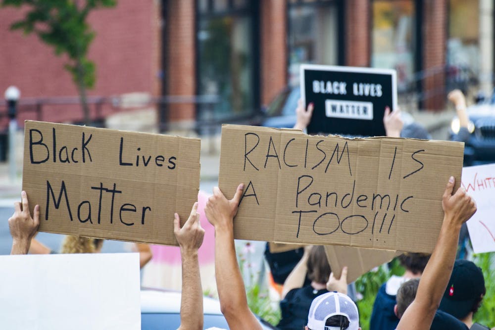 <p>Protesters hold signs above their heads June 9, 2020, outside the Monroe County Courthouse. A new IU study shows discussions related to BLM have increased since summer 2020.</p>