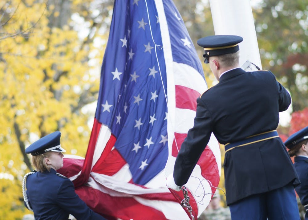 Members of the IU Army and Air Force Reserve Officer Training Corps color guard unfurl the flag to raise it during a sunrise Veterans Day ceremony on Friday. The ceremony, which was held outside of Franklin Hall, honored veterans and those currently serving in the armed forces.