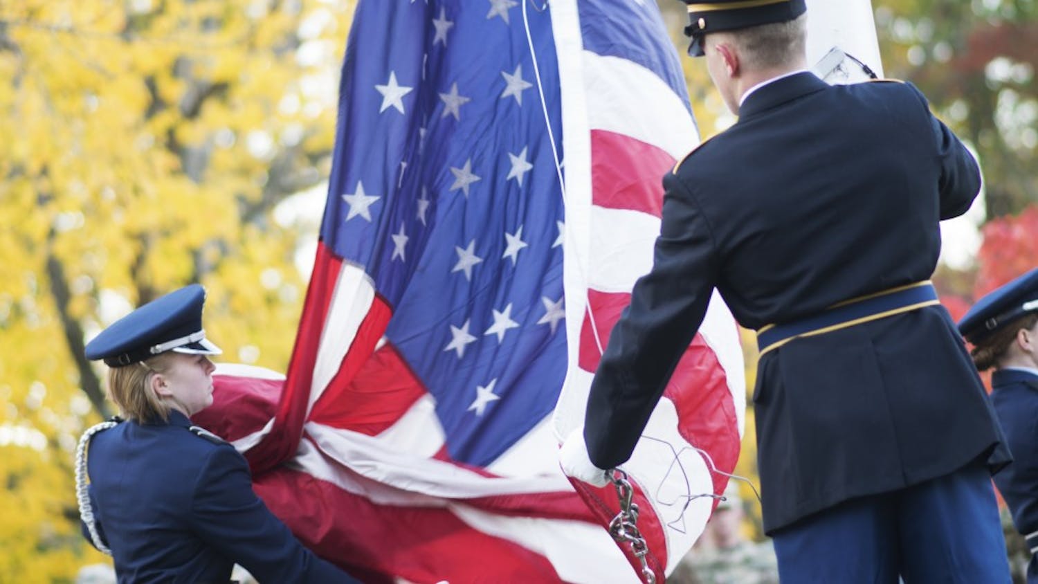 Members of the IU Army and Air Force Reserve Officer Training Corps color guard unfurl the flag to raise it during a sunrise Veterans Day ceremony on Friday. The ceremony, which was held outside of Franklin Hall, honored veterans and those currently serving in the armed forces.