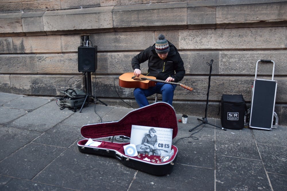 A man plays the guitar on his lap while sitting on the streets of Scotland. He was just one street musician music columnist Hannah Reed stumbled across while in Scotland.