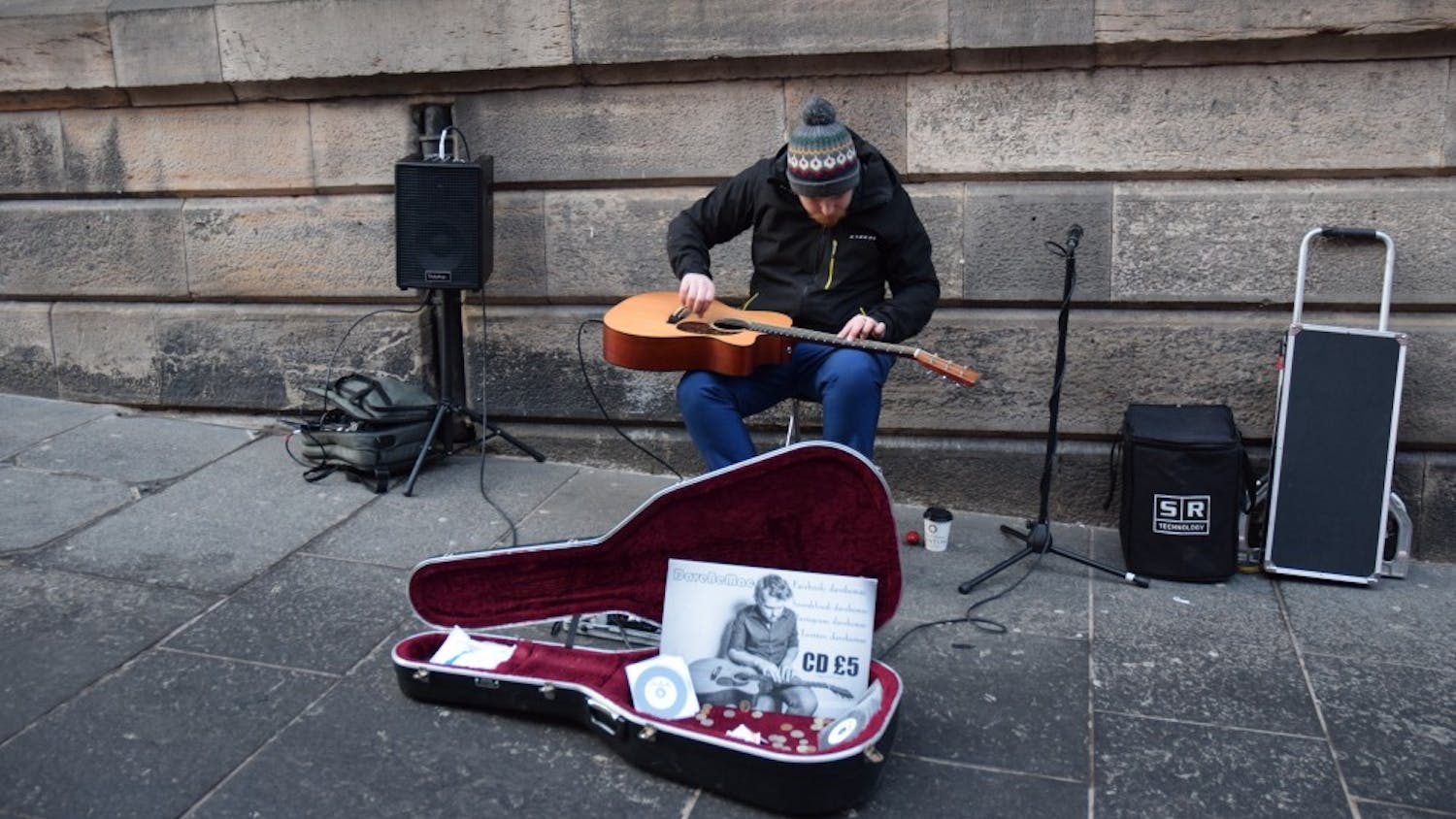 A man plays the guitar on his lap while sitting on the streets of Scotland. He was just one street musician music columnist Hannah Reed stumbled across while in Scotland.