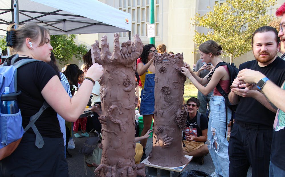 <p>People add to sculptures at the IU Ceramics Guild tent during First Thursdays on Sept. 1 at the Fine Arts Plaza. Many booths had interactive activities for students as well as community members.</p>