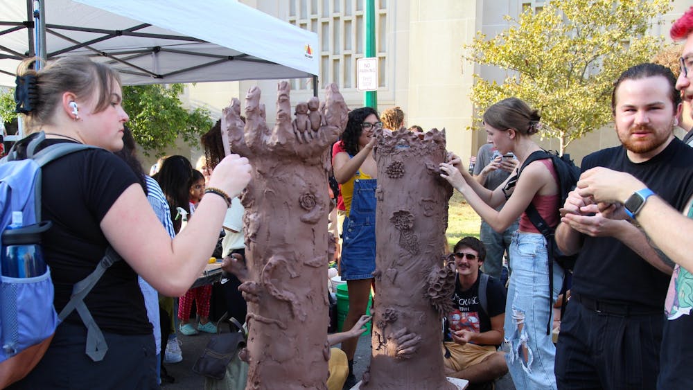 People add to sculptures at the IU Ceramics Guild tent during First Thursdays on Sept. 1 at the Fine Arts Plaza. Many booths had interactive activities for students as well as community members.