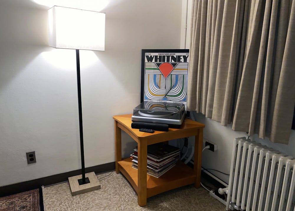 <p>A stack of vinyl records sits on a shelf below a record player Sept. 29 in University East Apartments. </p>
