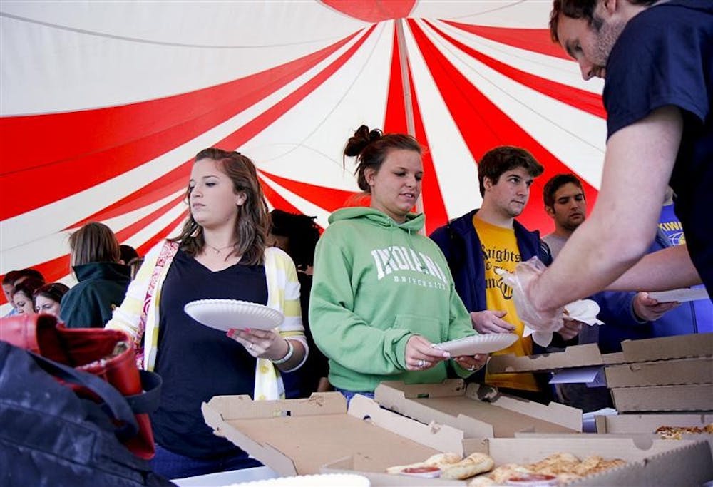 Students line up to get pizza Thursday afternoon in Dunn Meadow. Proceeds from Pizza Mania benefitted Mother Hubbard's Cupboard, a local food pantry whose mission is to provide healthful, wholesome foods to people in need, as well as nutrition and gardening education.