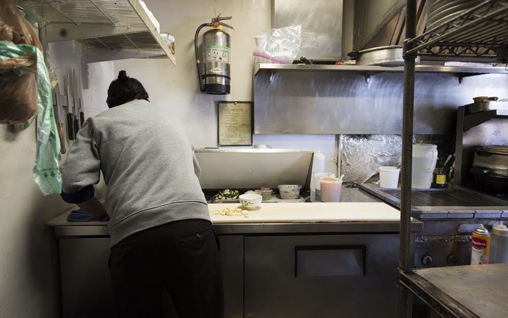 Chef Pema Wangchen crushes garlic for the first meal of the night at Little Tibet on 4th Street. Wangchen says their most popular dishes are their momos, curry and pad thai. 