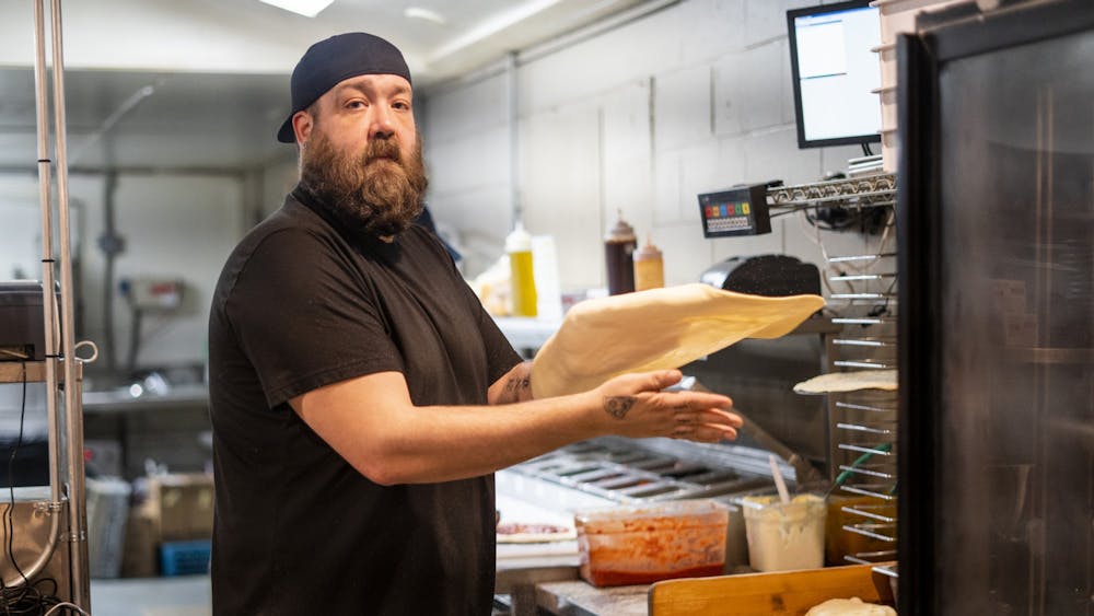 Kitchen manager Jake Garner flips pizza dough Feb. 6 at Trailhead Pizzeria. Trailhead Pizzeria reopened in late January after a car drove through and destroyed part of the restaurant in September.  