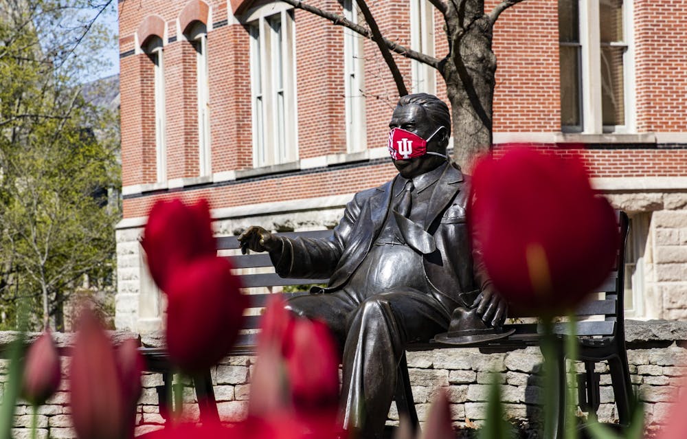 A.﻿ 4月20日，在国际大学校园里，赫尔曼B威尔斯雕像的脸上戴着面具。