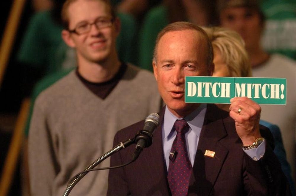Newly re-elected Indiana Gov. Mitch Daniels holds a campaign sign from his Democratic rival Jill Long Thompson during a victory celebration Tuesday night at Conseco Fieldhouse in Indianapolis.
