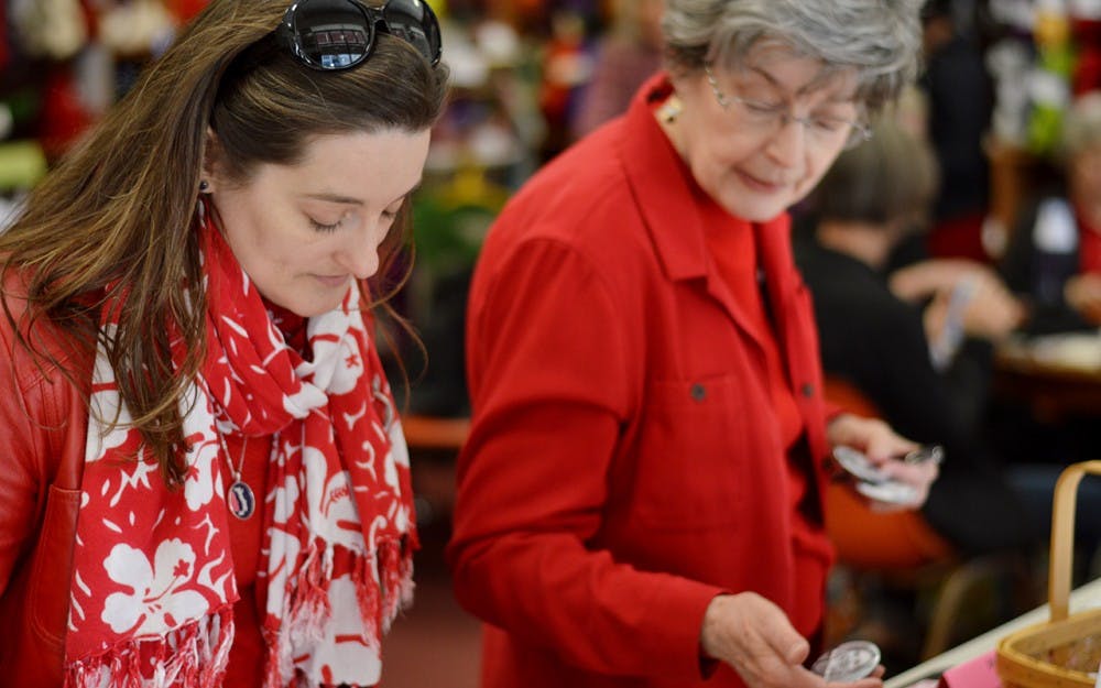 Julie Hardesty and her mother Mary Hardesty look through pins and information for sending postcards to government representatives Wednesday. Julie Hardesty participated in A Day Without a Woman by taking off work, attending feminist readings on campus and joining the gathering at Yarns Unlimited.