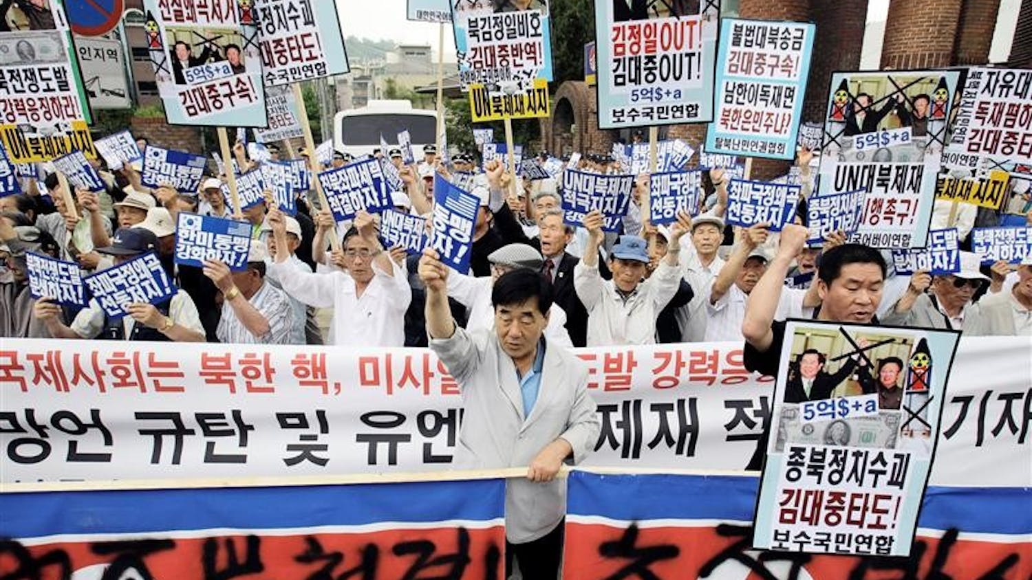 South Korean protesters shout slogans during a rally against North Korea's nuclear program while denouncing the ninth anniversary of the June 2000 summit between the South Korean President Kim Dae-jung and North Korean leader Kim Jong Il, in front of the former South President Kim's house in Seoul, South Korea, Sunday, June 14, 2009. North Korea's communist regime has warned of a nuclear war on the Korean peninsula while vowing to step up its atomic bomb-making program in defiance of new U.N. sanctions. The Korean read "'Annihilate North Korea at the start of war and Support U.N. sanctions." 