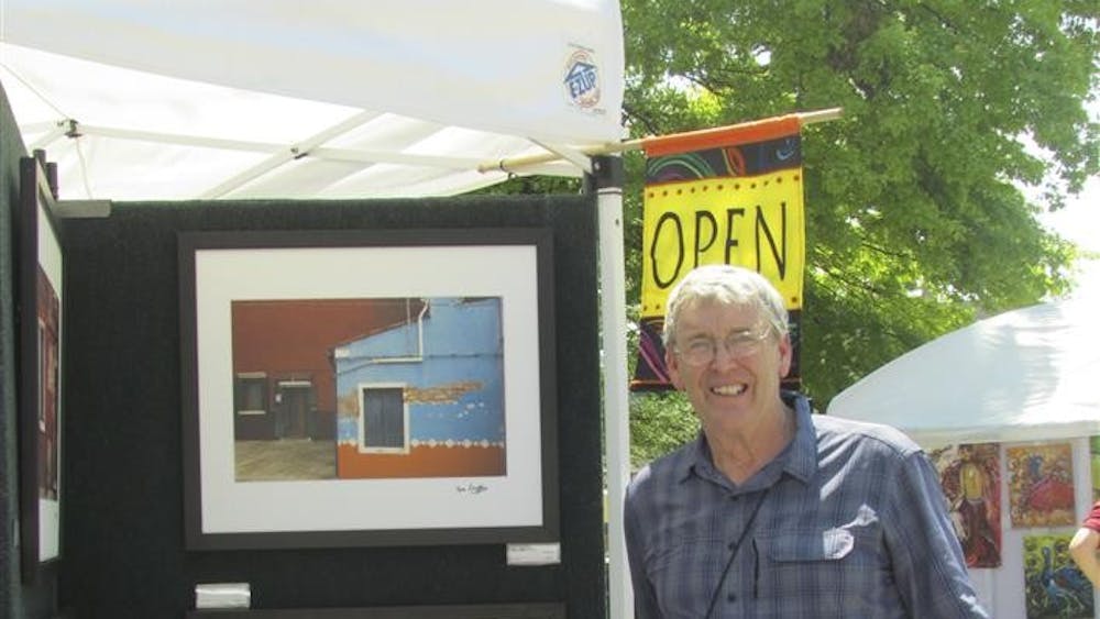 Tom Duffy stands with his photography at the 34th annual Arts Fair on the Square. Duffy's work was on display at&nbsp;By Hand Gallery for November's First Friday Gallery Walk.