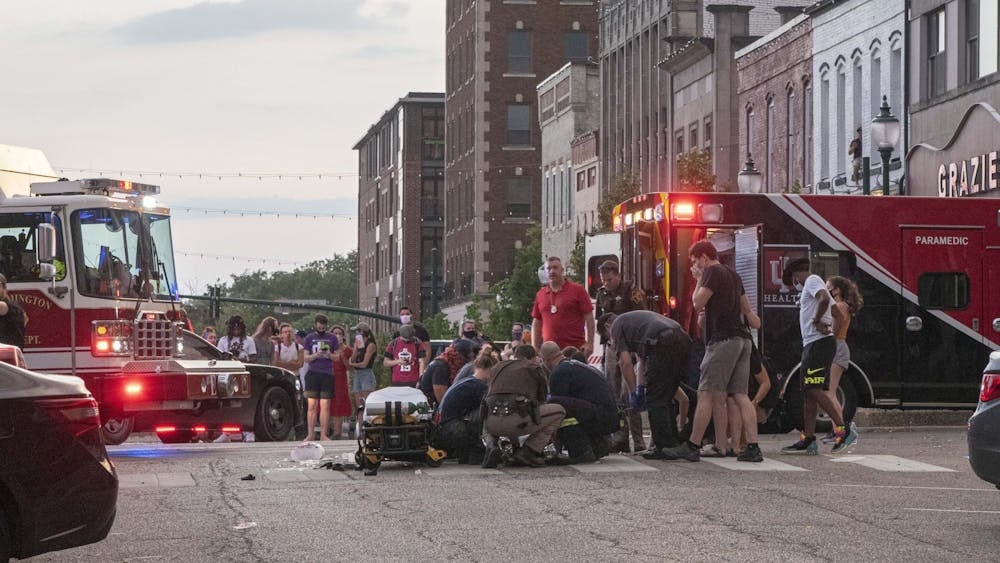 Paramedics, firefighters and law enforcement officers tend to a protester who was struck by a car July 6 just after the conclusion of the protest in downtown Bloomington. The car sped off after hitting multiple protesters and carrying them on the hood of the car before they were eventually flung off.